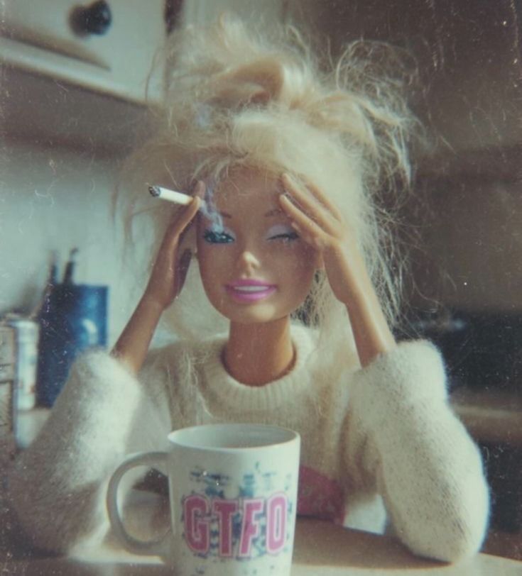 Barbie looking rough with disheveled hair, drinking coffee and smoking a cigarette 