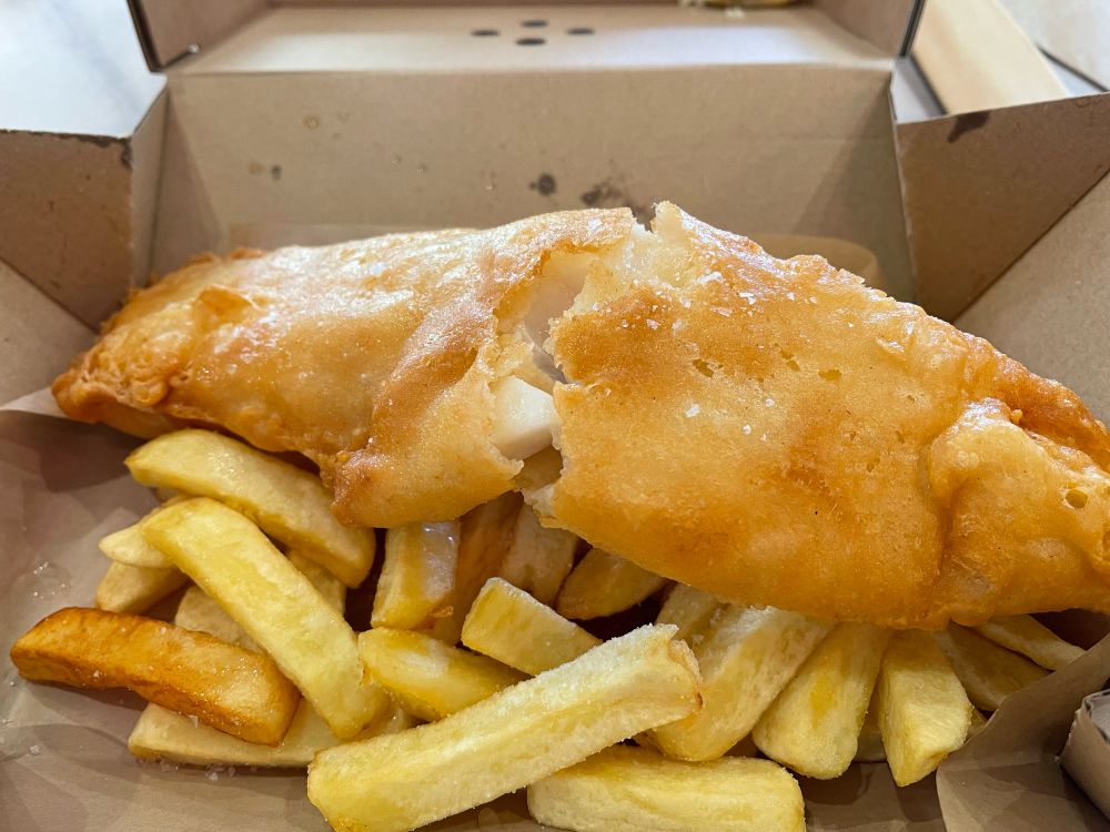 Some fish and chips in a small cardboard box