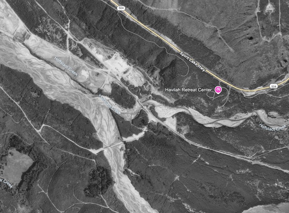 Aerial view looking southwest over the North Fork Toutle River valley near Hoffstadt Creek. The site of Weyerhaeuser’s former Camp Baker lies below the Spirit Lake Highway, partly buried beneath sediment from the May 18, 1980 eruption. Taken July 1990. Google Earth imagery.