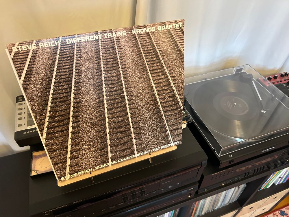 A record cover, which shows train tracks, next to a record player