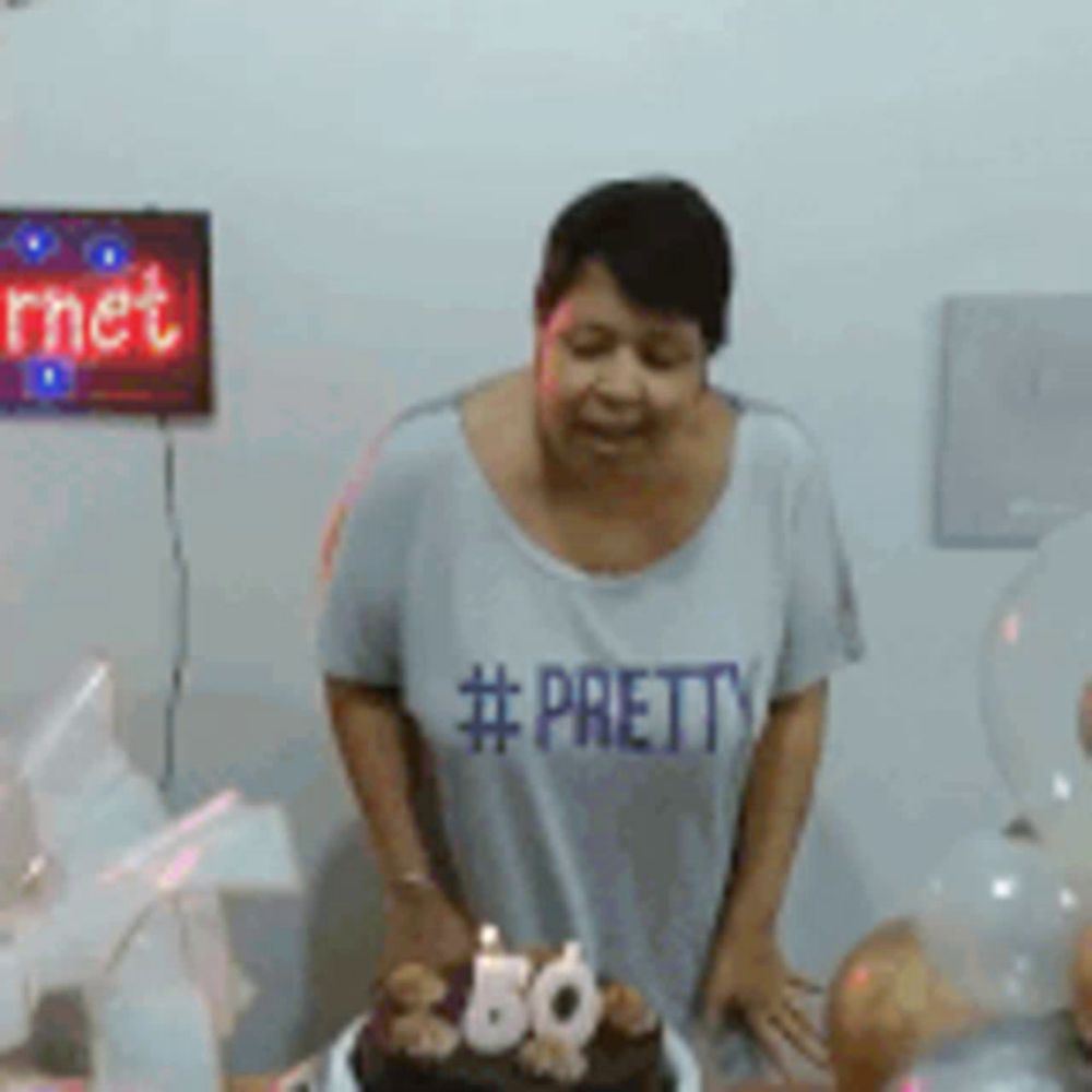 a woman wearing a #pretty shirt is cutting a cake