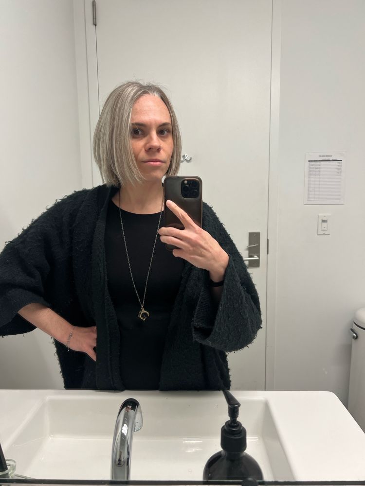 a tired lookin lady taking a mirror selfie