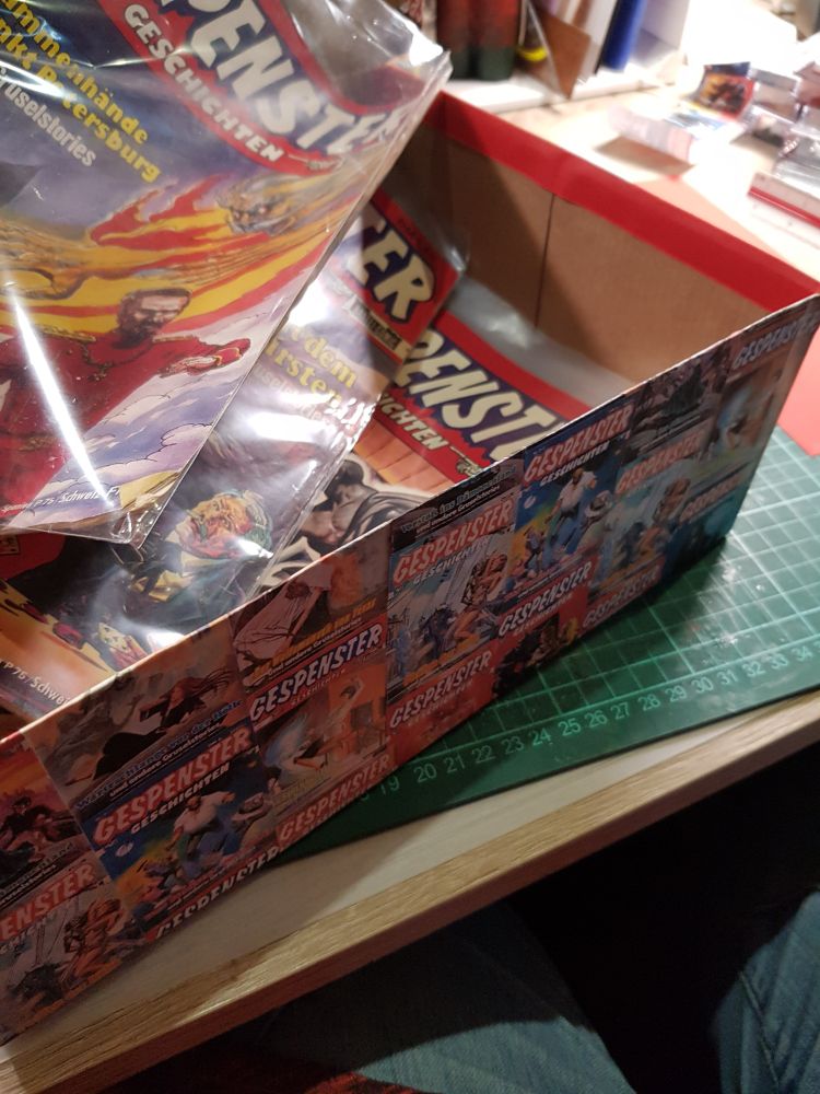 Geöffneter ehemaliger Schuhkarton mit Gespenster-Heften darin.