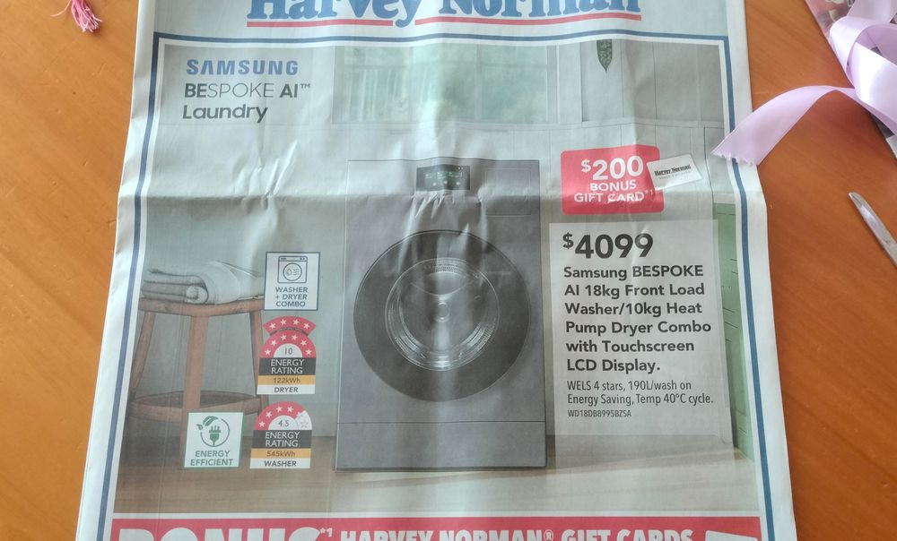 Newspaper advert of a bespoke AI laundry device, whatever that means. It's a washing machine and to me the circular door and stainless evokes HAL 9000 from 2001.