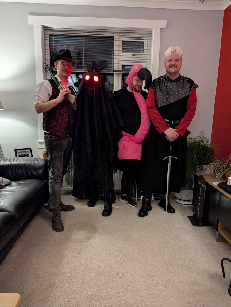 A group photograph of a man dressed as Dutch from Red Dead Redemption 2, Mothman, a man dressed as a flamingo and a other man dressed as Daemon Targaryen