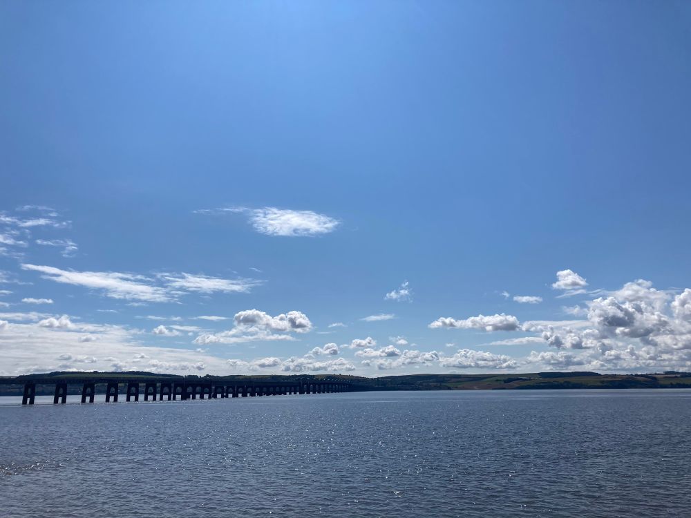 View across Tay Firth toward the rail bridge nearing midday it is bright with a few puffy clouds