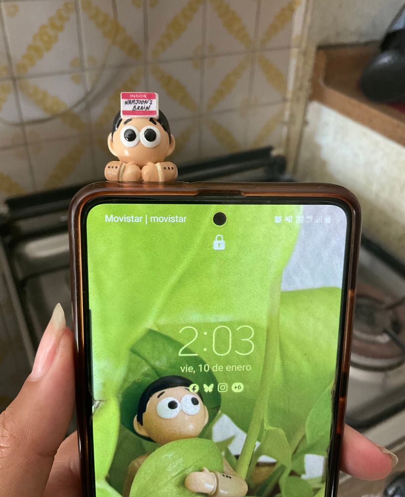 Close up shot of my phone with a tiny Lost Joon inspired hipper on top of it. Background is my thirld world kitchen.