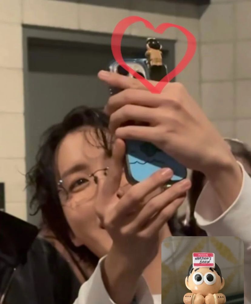 A photo of Jhope from BTS holding a phone with one of my hippers on it.