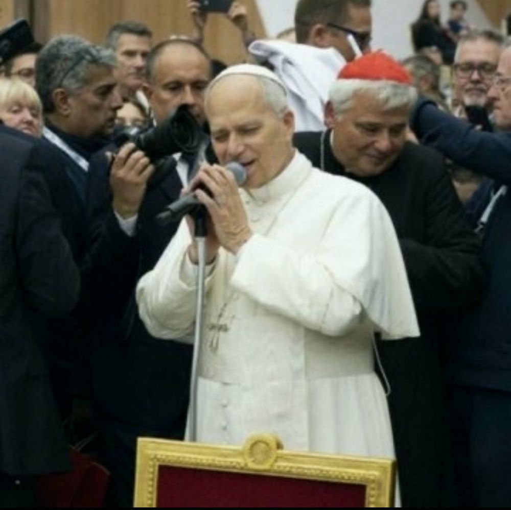 Picture of the pope and a microphone singing.
