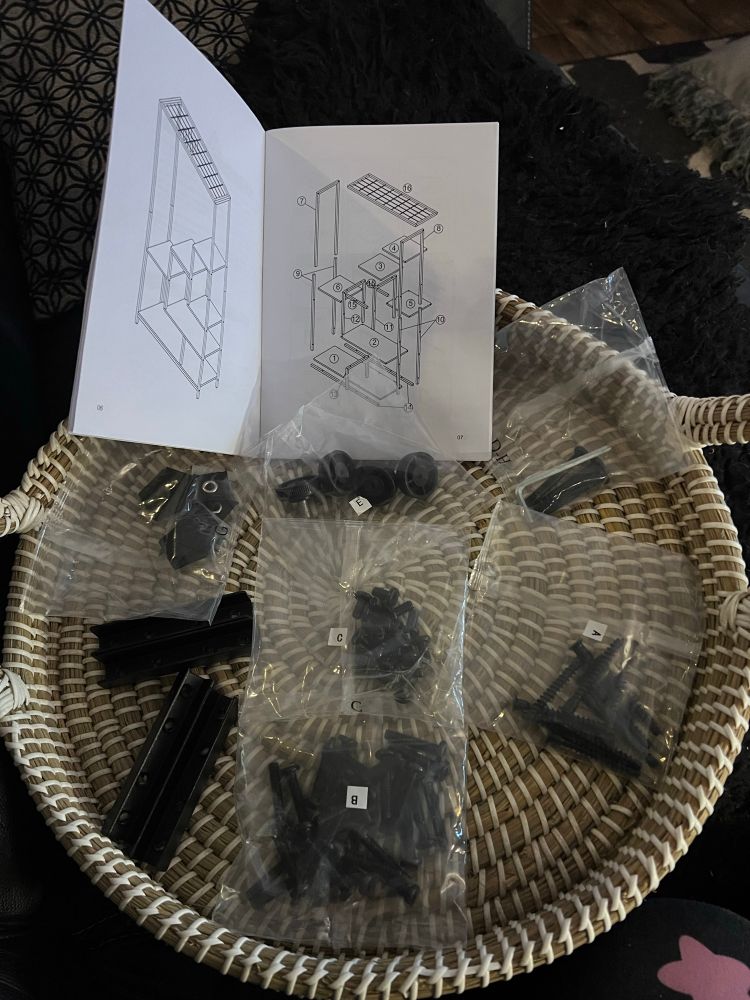 Instructions for furniture, a large circular woven tray with assorted bags of screws etc
