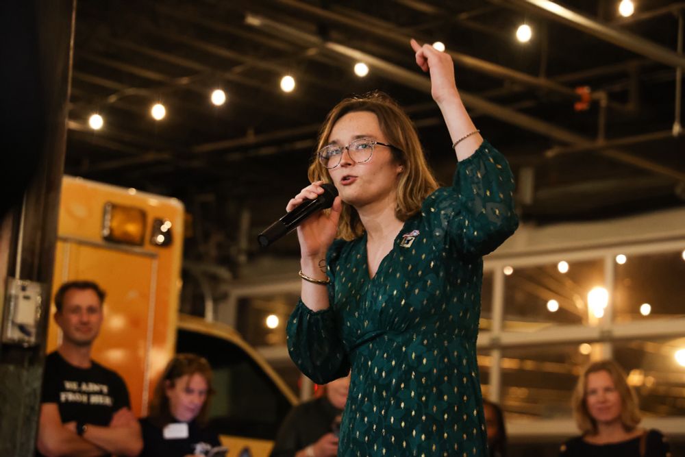Emma holds a microphone as she delivers her victory speech.