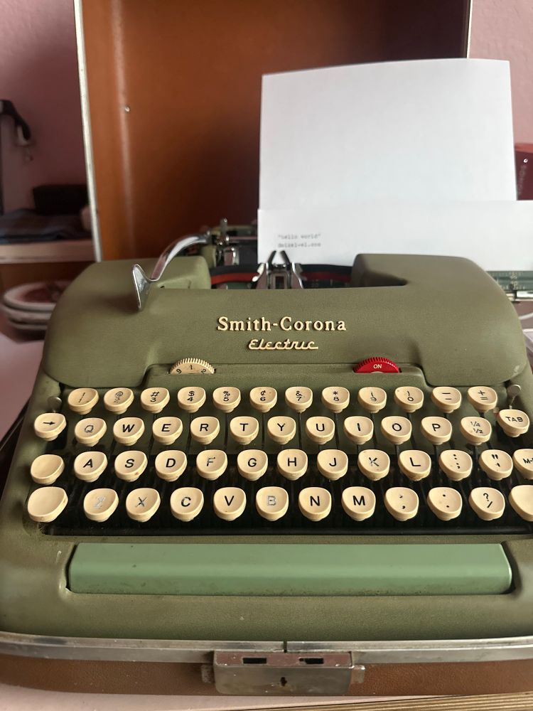 Smith-Corona electric type writer—in need of a new ribbon. Page says “hello world”