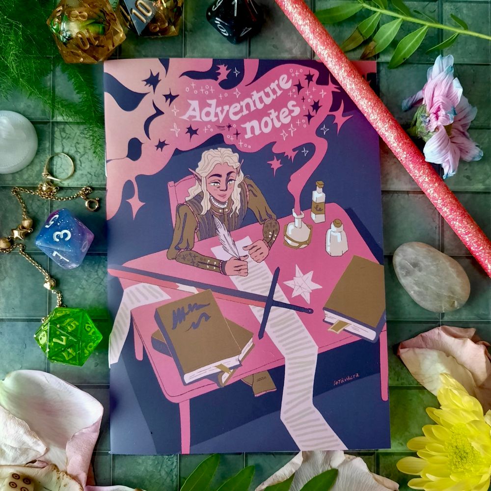 A small notebook. On the cover of the notebook is the text “Adventure notes” and an illustration of an elf. The elf is sitting by a desk and writes a long scroll. 