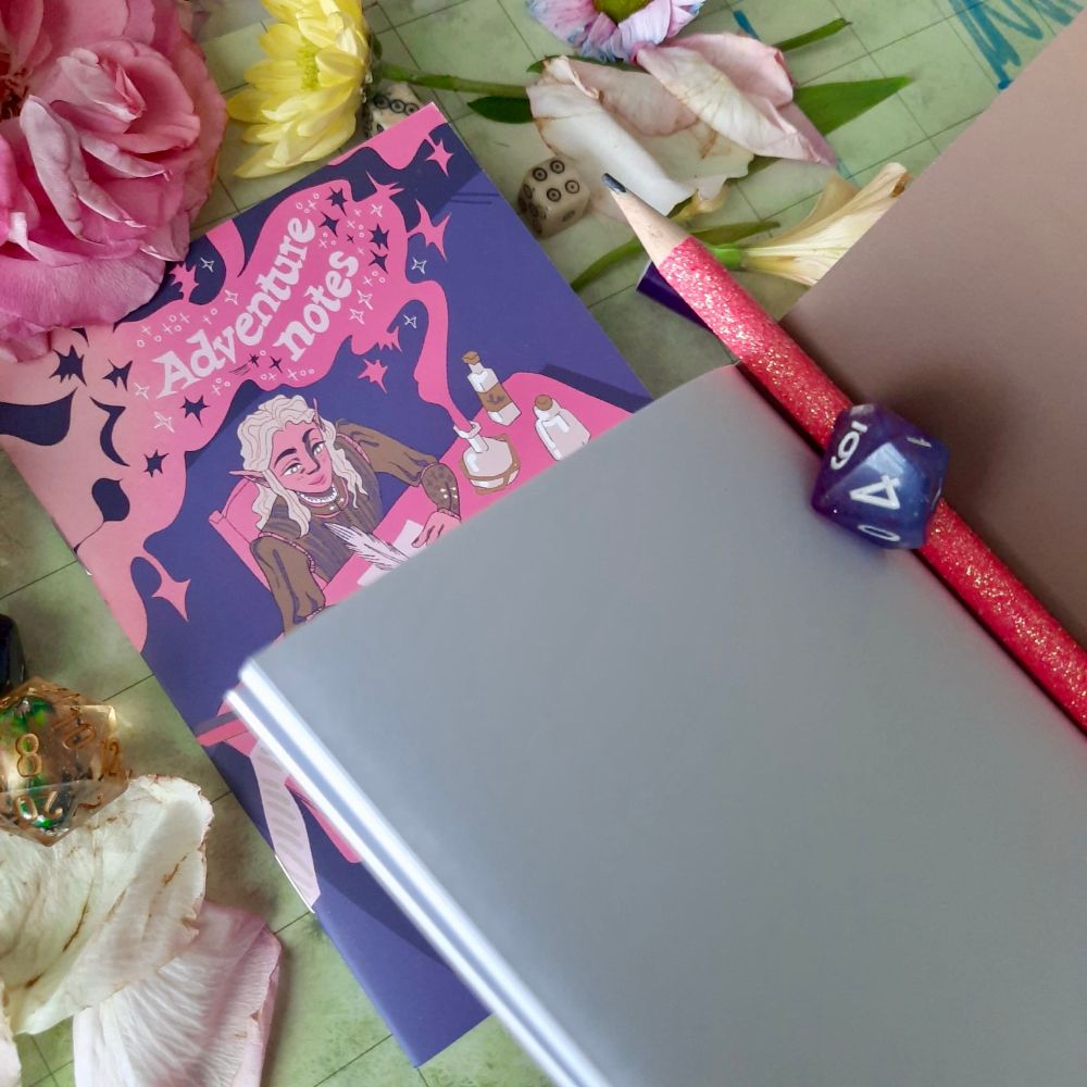 An empty notebook with blank pages. I’m the background is the notebook with the elf illustration.