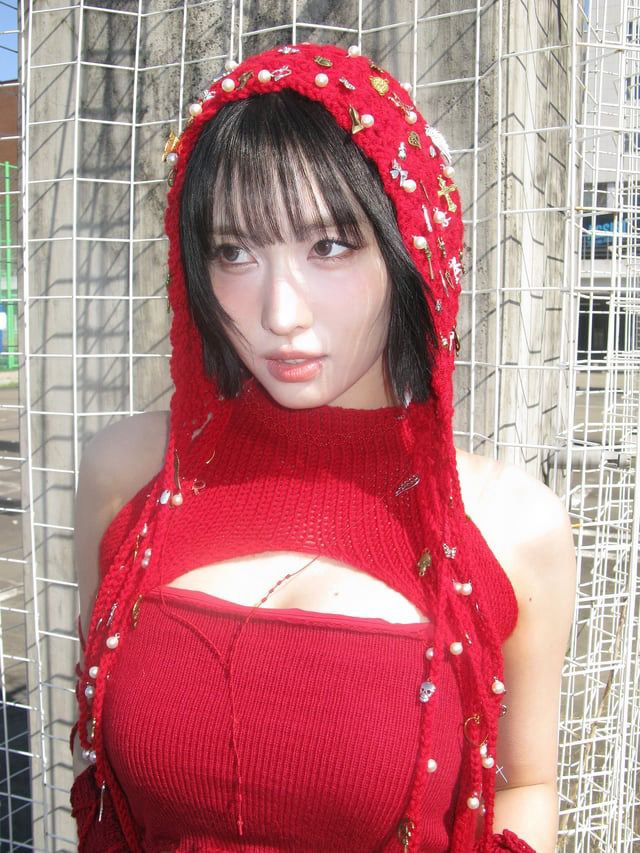 Close up Photo of momo from kpop group twice in a red performance outfit with short black hair 