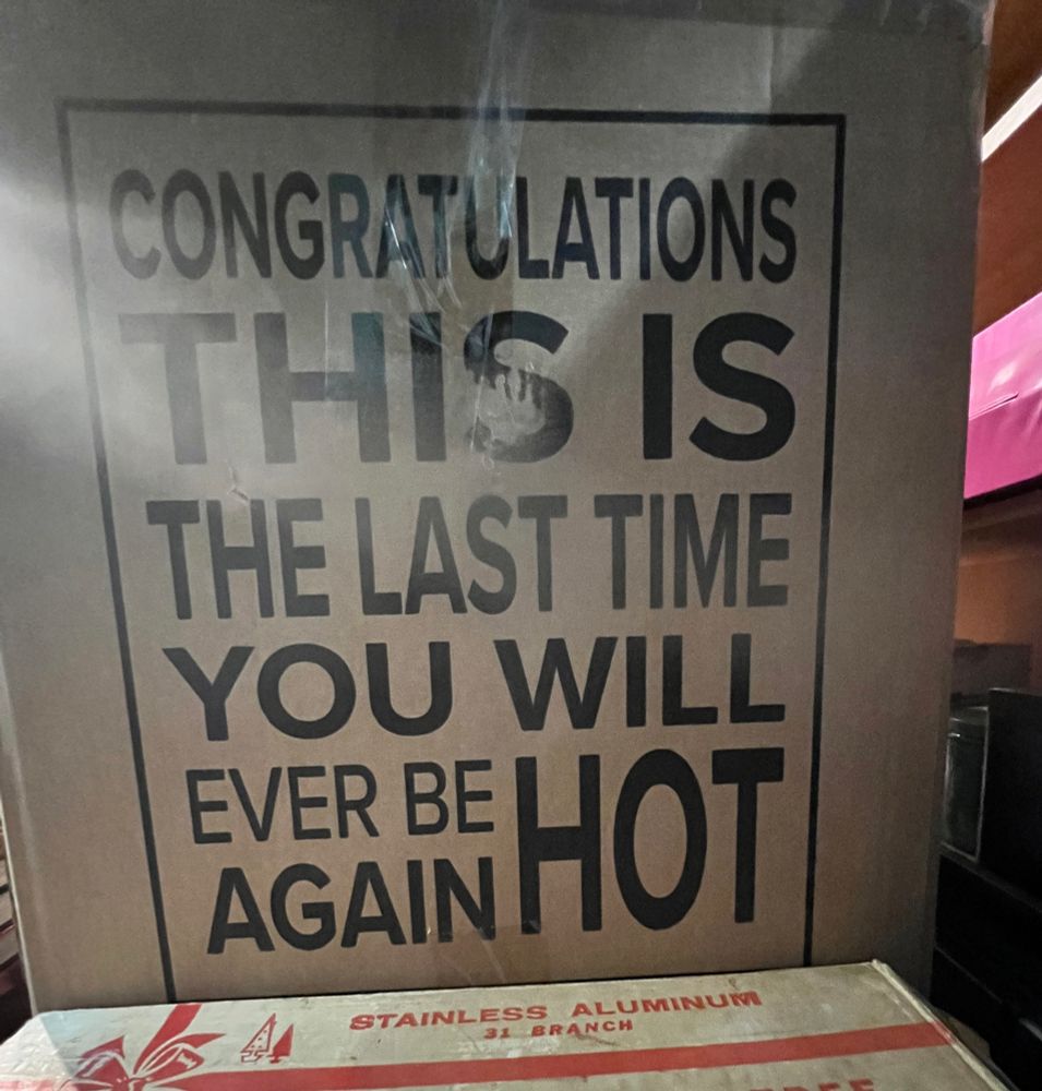 Cardboard box with ‘CONGRATULATIONS THIS IS THE LAST TIME YOU WILL EVER BE HOT’ written on it