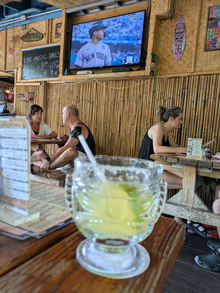 Margarita in a Tiki glass, in a Tiki bar. World Series on the tv
