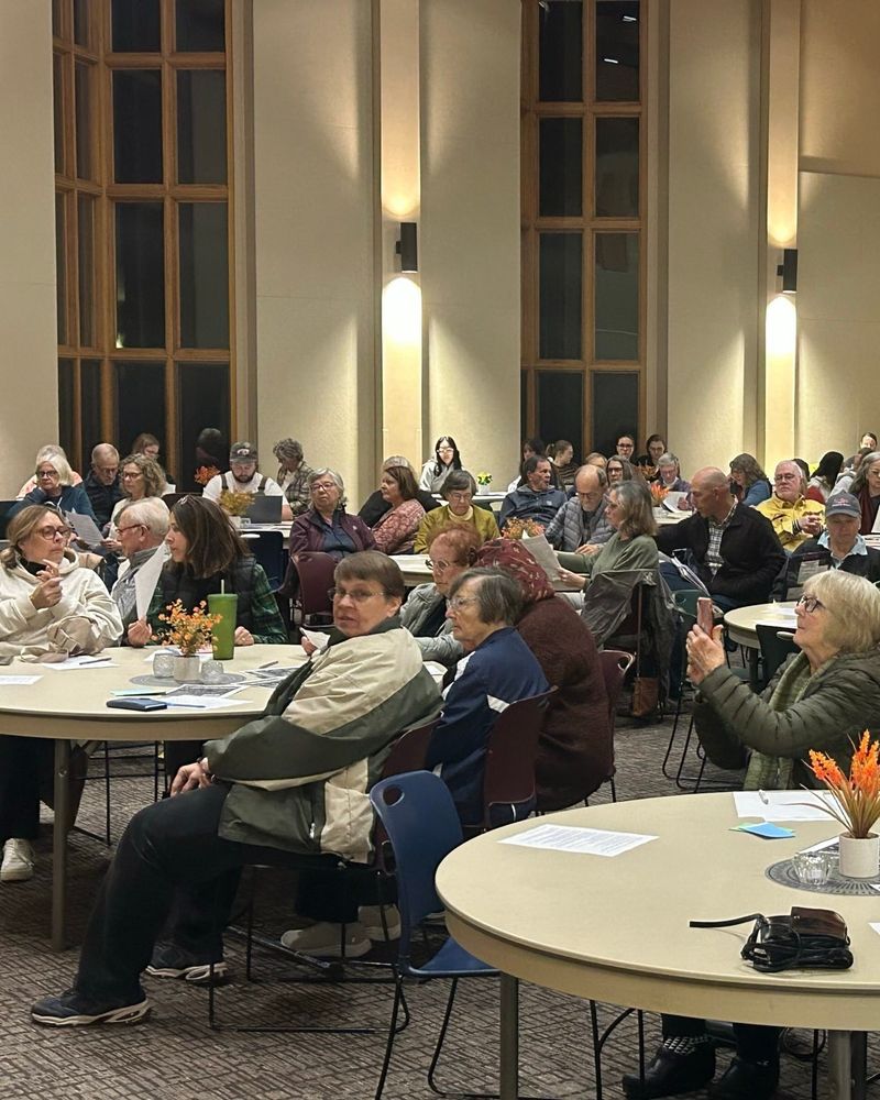 ISAIAH leaders sit around tables and look toward front of room