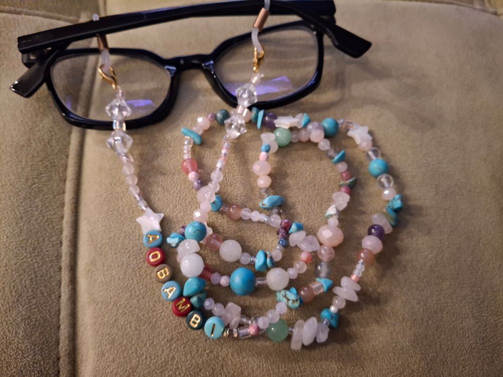 Beaded glasses chain made with a mix of beads of plastic, glass, and natural stone. There are also a few multicolored plastic alphabeads that read "aobambi".