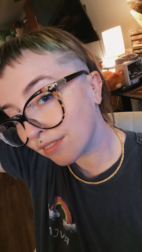 Beebs smiling with a new hair cut, sitting in her desk area