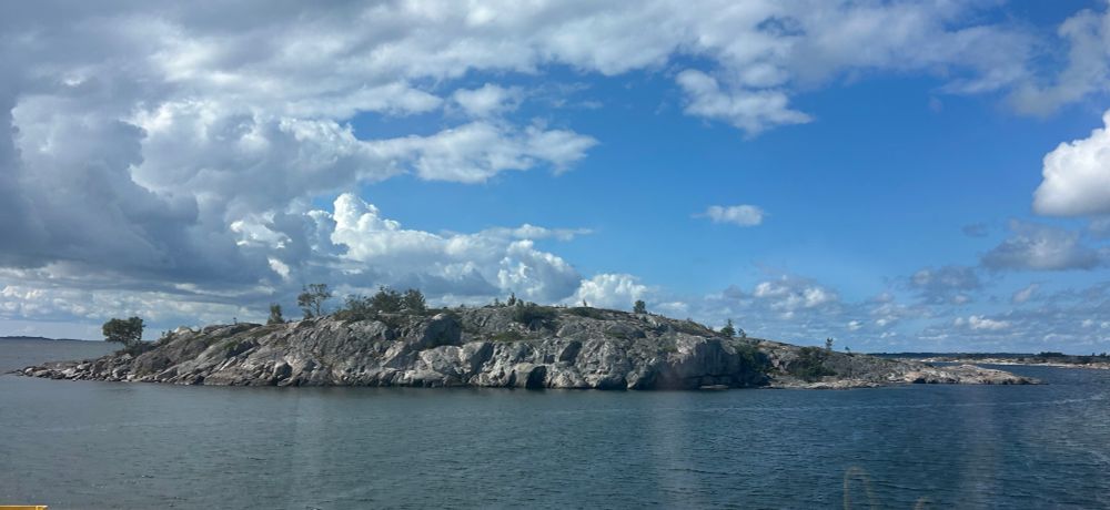 Merestä nouseva kallio, jossa kasvaa jokunen puu. Toinen sanoisi luodoksi, toinen saareksi. 