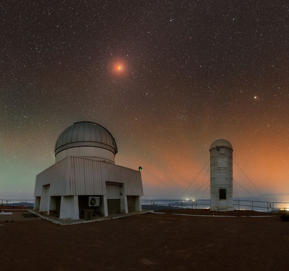 The US Naval Observatory Deep South Telescope and the DIMM2 Seeing Monitor sit side by side on Cerro Tololo Inter-American Observatory (CTIO), a Program of NSF NOIRLab, under the colorful sky of the lunar eclipse in March 2025. 