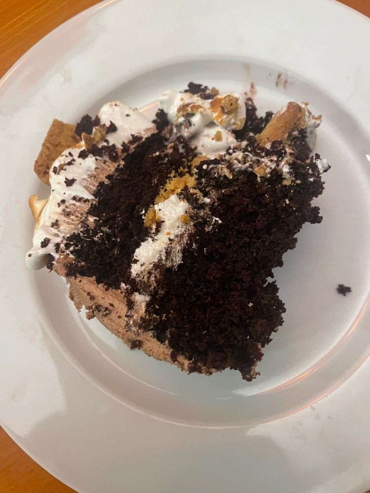 A slice of chocolate cake filled with chocolate ganache, marshmallow cream, and chocolate frosting 