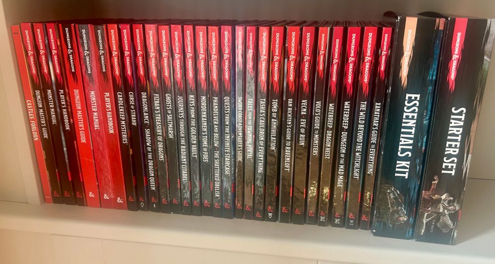 Lots of D&D books and boxed sets on a shelf.