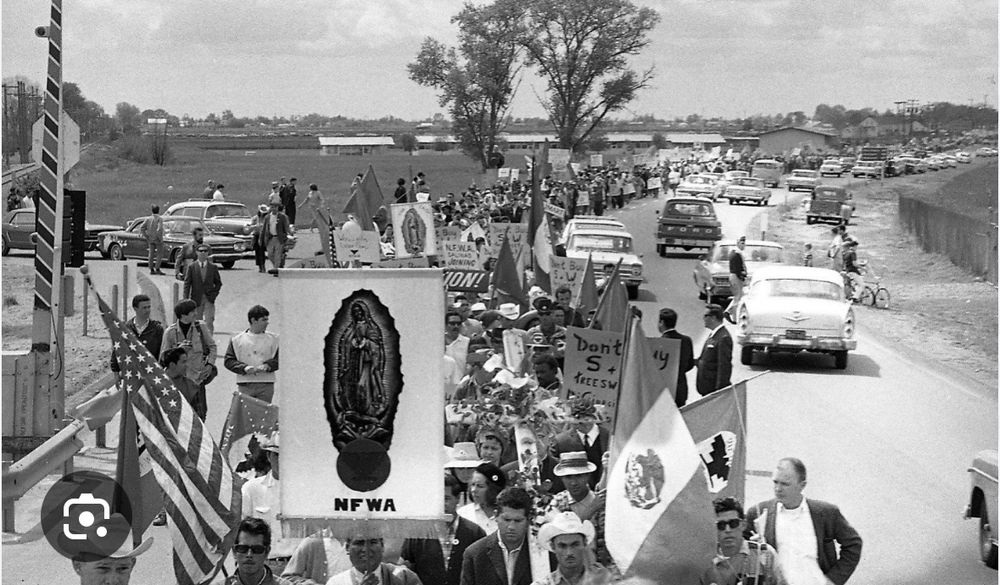 Delano strike march with several flags: US, Mexican, UFW, la Virgen.