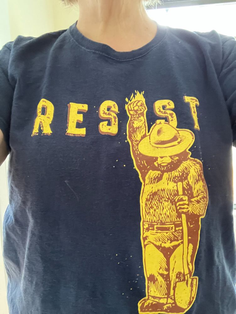Me, wearing a navy blue t-shirt with "RESIST" on the front, with Smoky Bear's raised fist as the "I" in resist.