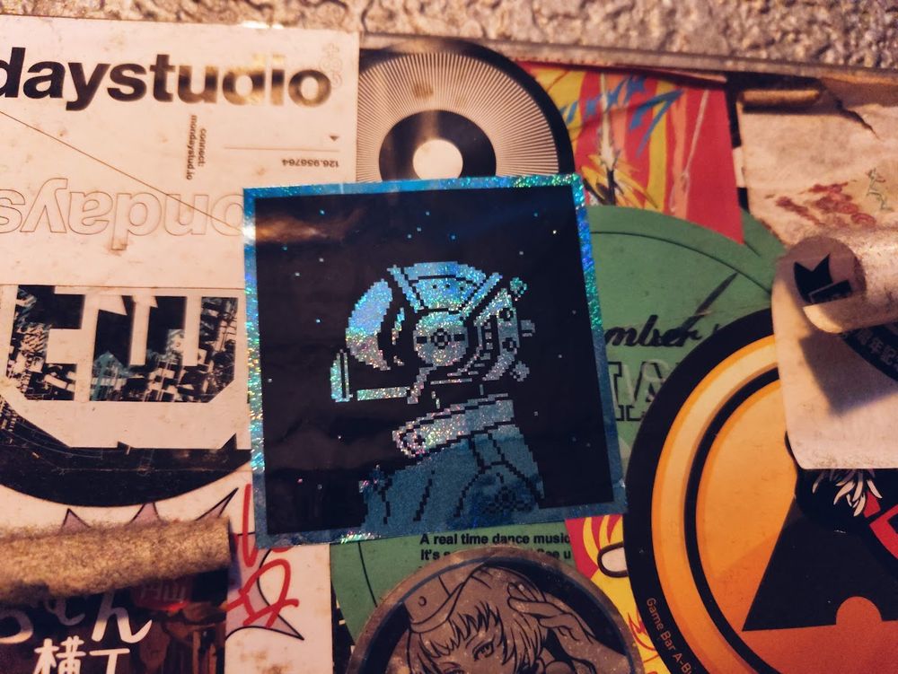 Quasar cover art sticker on the wall at Mogra in Akihabara