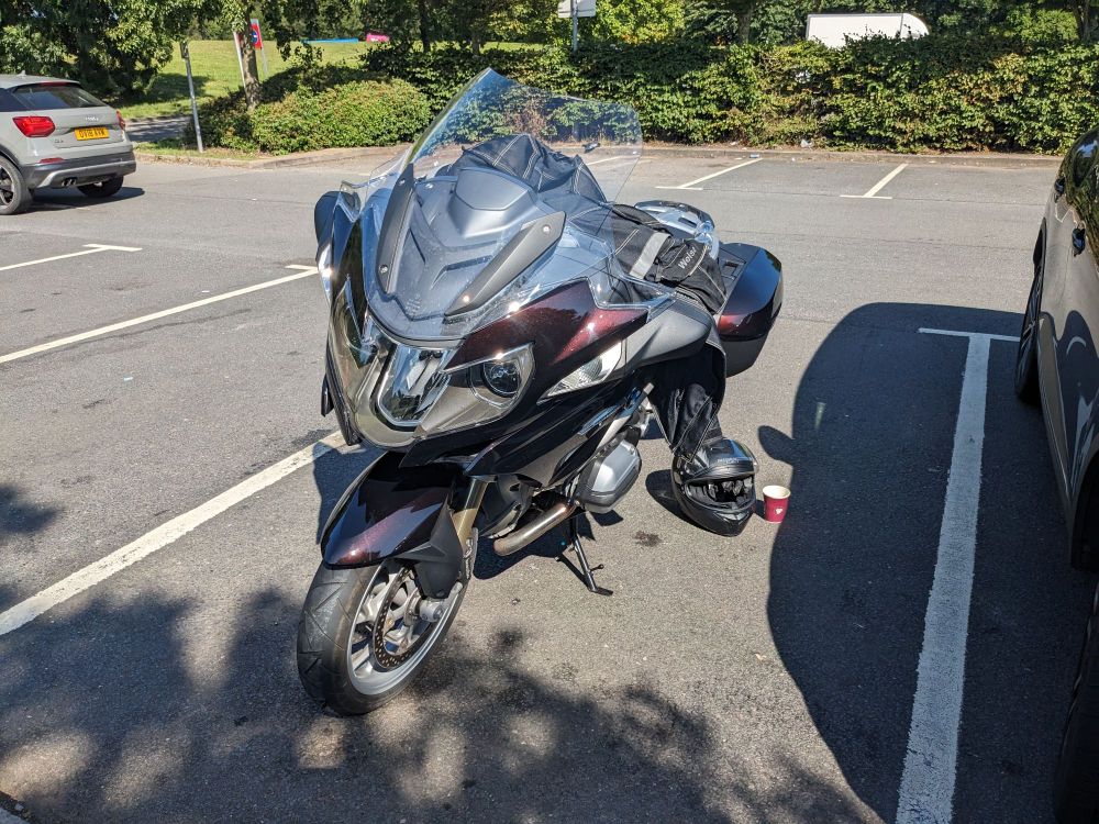 Black BMW R1200RT motorcycle parked in the sun.