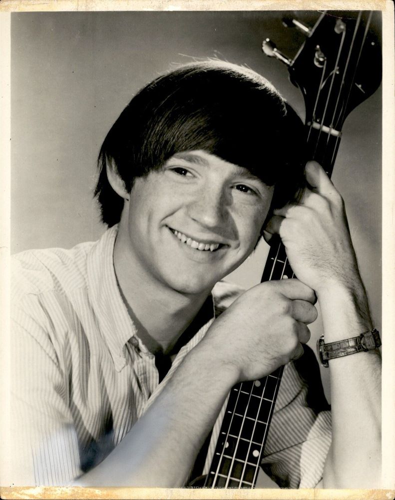 Peter Tork smiling in an early, black and white Monkees promo photo.