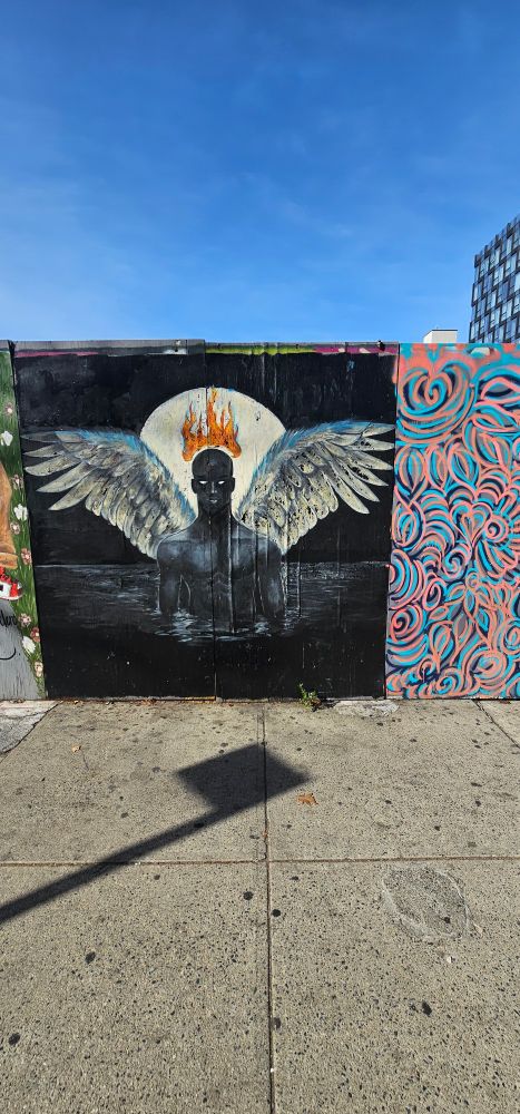 graffiti image of a noir man with angel wings coming out of water with the moon. behind in and a fire red halo.