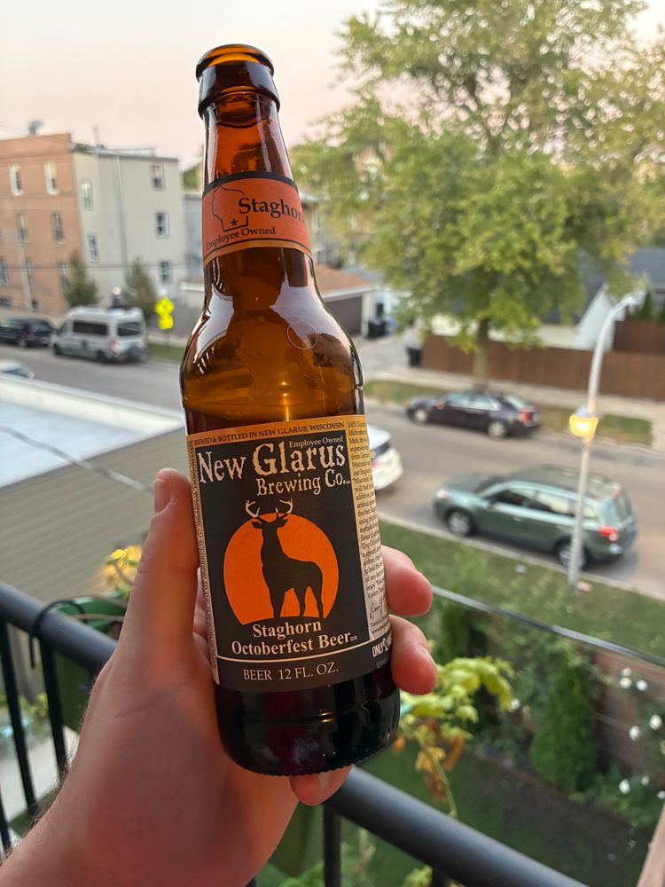 A bottle of New Glarus Staghorn Oktoberfest beer, held aloft on my back patio 