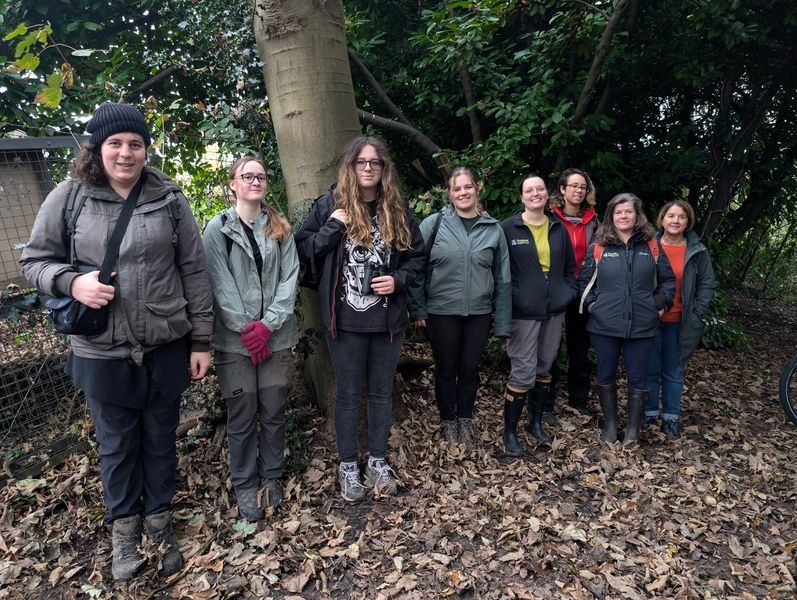 A group of 6 smiling Youth Rangers in winter clothes under a tree with 2 staff at The Deneway urban nature reserve