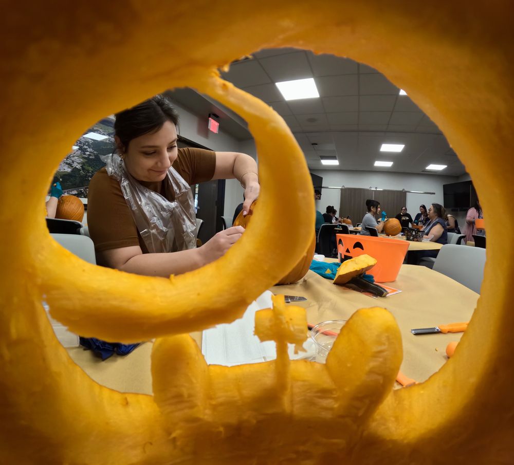 Point of view from inside a pumpkin being carved. An SwRI employee enjoys the lunchtime activity.