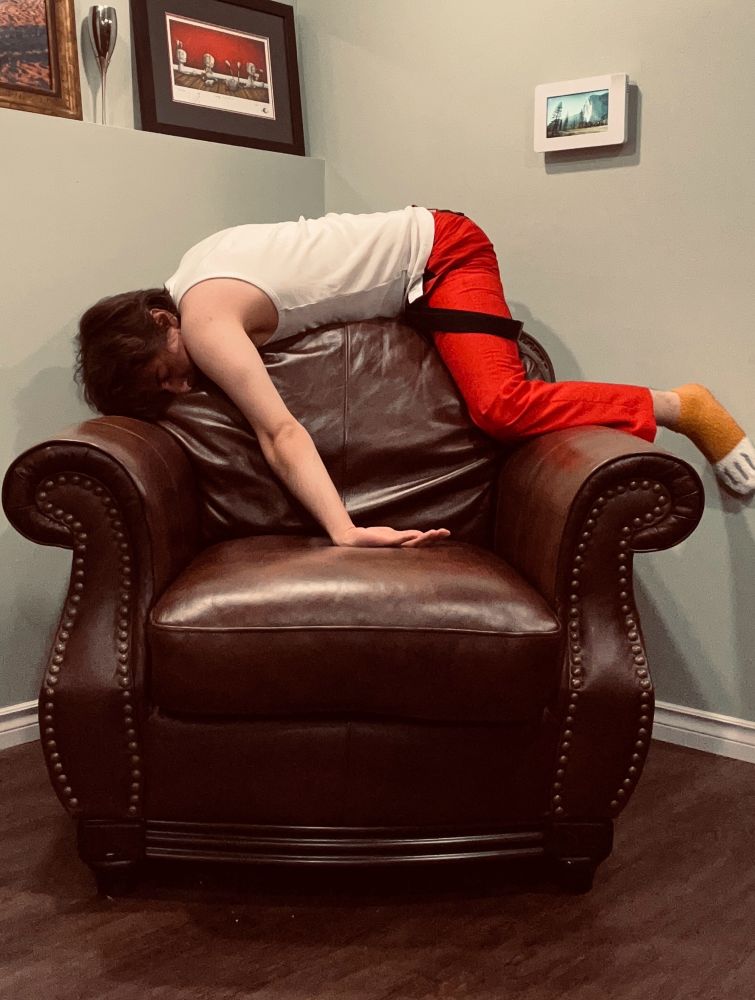 AlexTheShiba cosplaying as Zib from lackadaisy and recreating some of the positions he was in during the video of him sleeping in a chair. Position is him laying on the top of the chair’s backrest 