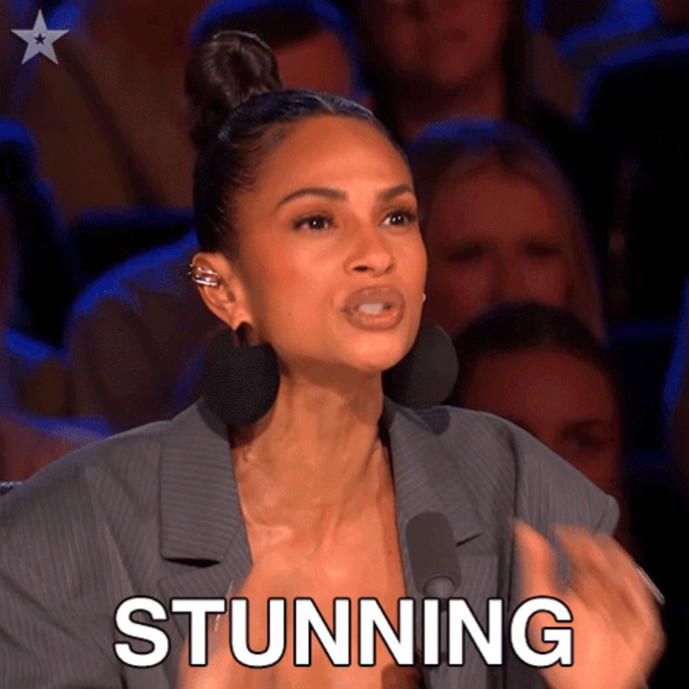 a woman in front of a crowd with the word stunning written on her face