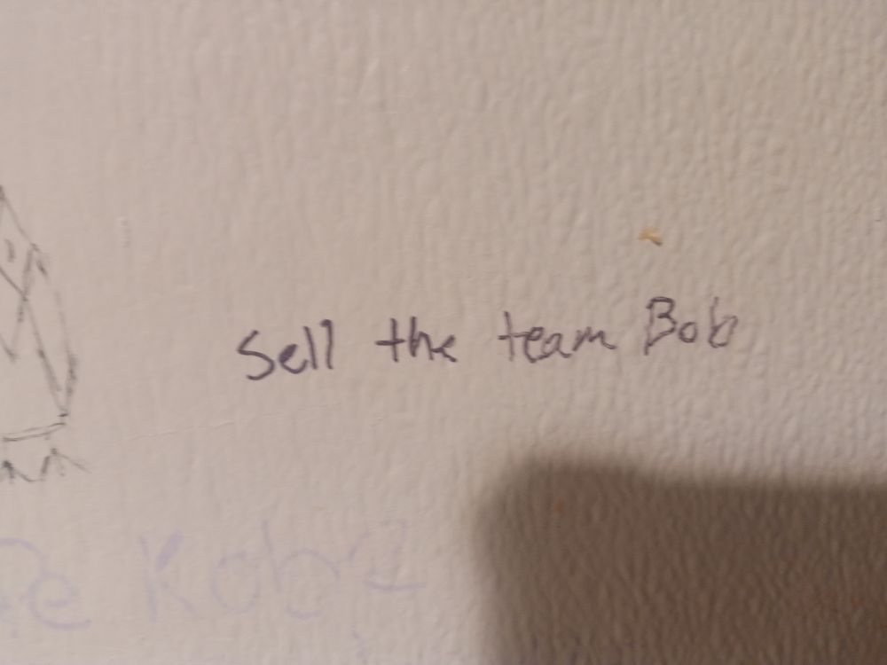 Bathroom graffiti that says "Sell the team, Bob"