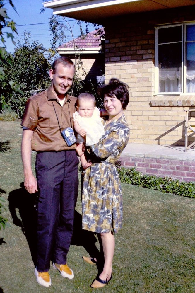 Xmas 1962, Melbourne. A stylish young couple – a man, a woman – on lawn outside a suburban brick-and-tile house. The woman holds a baby (reader, that baby is me). They’re all squinting into the December sun.