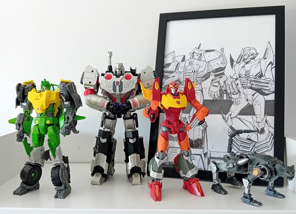 IDW styled toys of Springer, Megatron, Rodimus and Ravage alongside a piece by Nick Roche of Springer and Rodimus having a drink at a bar. 