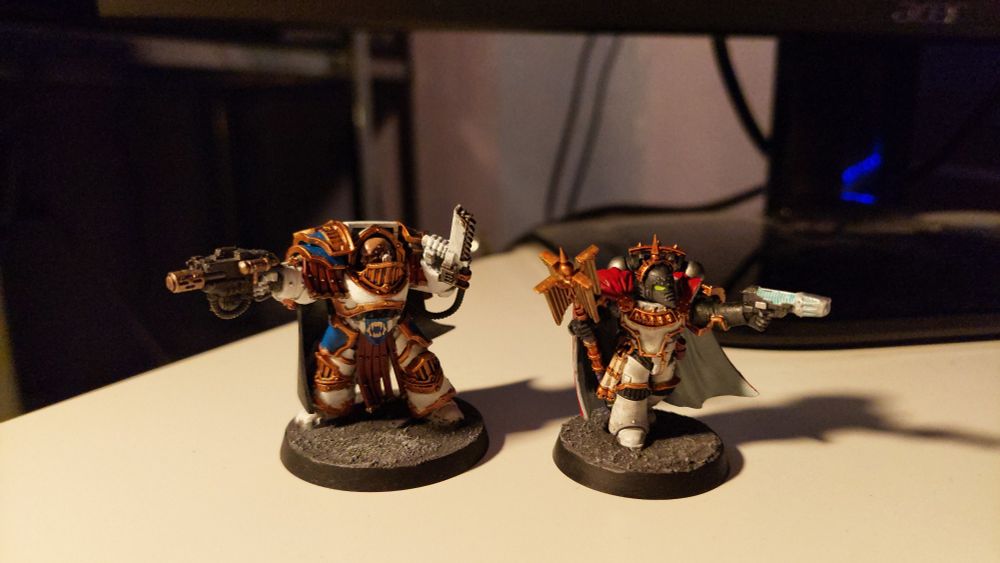 Two Horus Heresy characters next to eachother, a Cataphractii Praetor and a Chaplain Consul.