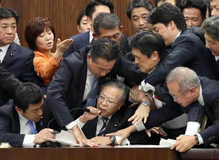 That image of a bunch of Japanese parliament members crowding around trying to stop one guy from saying something