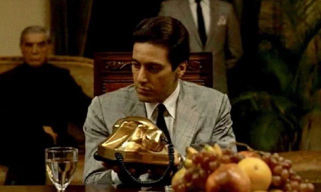 Scene from The Godfather, Part II, where a US company gives a dictator a gold phone