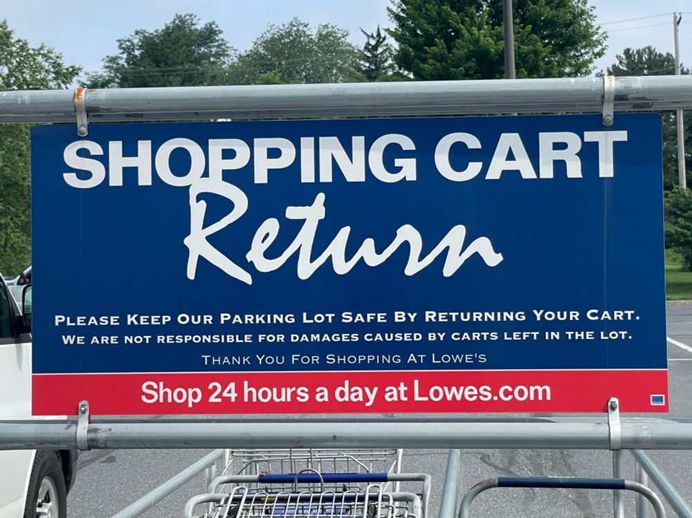sign in parking lot reads:

SHOPPING CART (in sans serif all caps)
RETURN (in fun script)