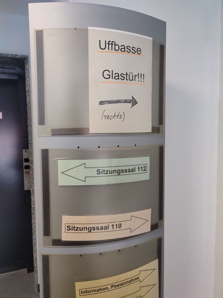 Hinweisschild "Uffbasse Glastür rechts!!!"