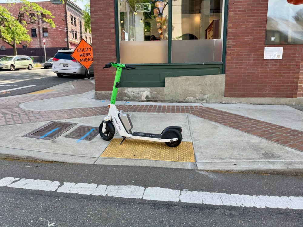 electric scooter on "sharing" network blocking a sidewalk ramp
