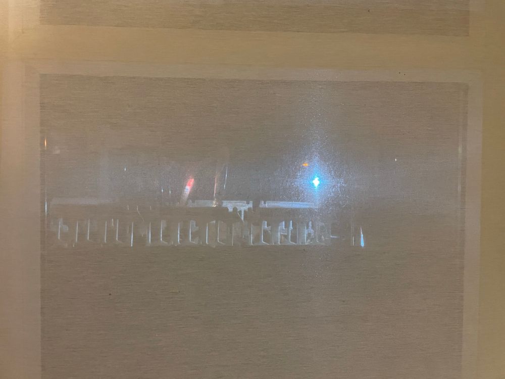 The flashing lights from road works seen through a window blind 