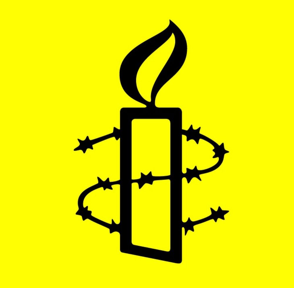 Amnesty International logo of a lit candle with a strand of barbed-wire around it.